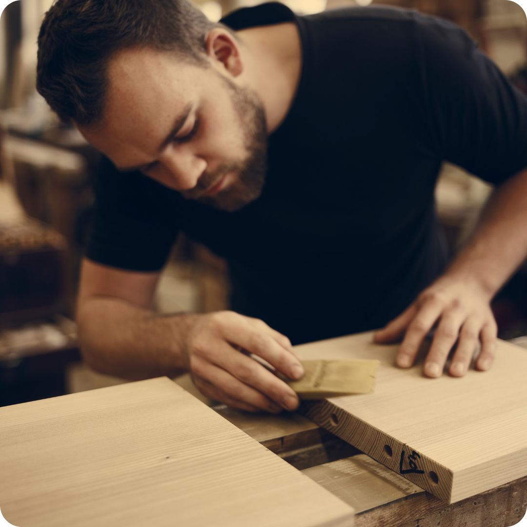 Meubelmaker schuurt vakkundig het massief eikenhouten