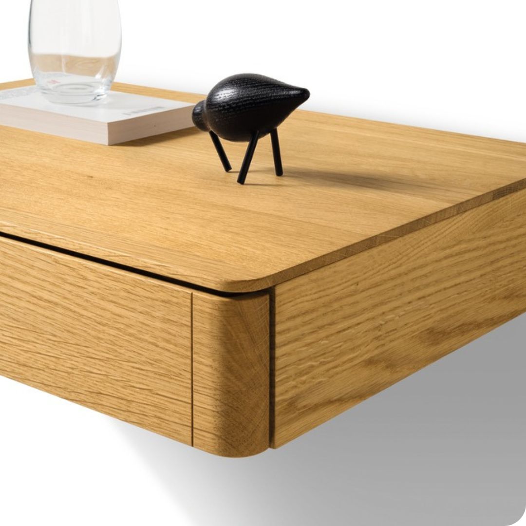 Zwevend eikenhouten nachtkastje gemonteerd aan de muur naast een massief houten bedframe